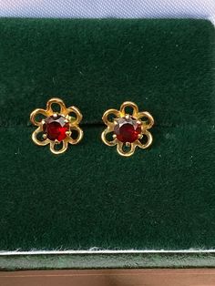 Vintage stud earrings made of 9ct gold, floral shape with garnets at the centre. Diameter 8mm. Formal Round Gemstone Flower Earrings, 14k Gold Round Flower Earrings For Formal Events, Yellow Gold Garnet Earrings For Anniversary, Yellow Gold Garnet Round Earrings, Gold Claddagh Ring, Vintage Stud Earrings, Tanzanite Diamond, Dream Board, Garnet Rings