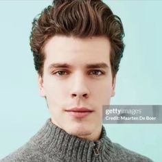 a young man wearing a turtle neck sweater looking at the camera with a serious look on his face