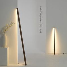 two white vases sitting next to each other on top of a table with lights