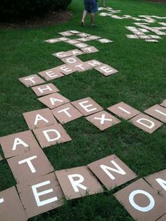 children playing in the grass with wooden tiles spelling out words that spell their name on them