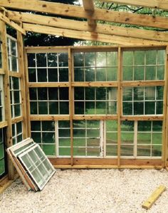 the inside of a greenhouse with several windows and gravel flooring in front of it