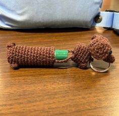 a crocheted dog keychain with a green plastic tag attached to it