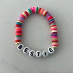 a bracelet with the word bestie spelled in white letters and colorful beads on it