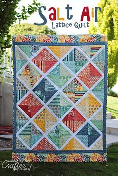 a colorful quilt hanging from the side of a tree in front of a sign that says salt