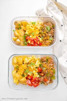 two plastic containers filled with food sitting on top of a white tablecloth next to each other