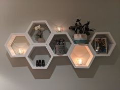 some shelves with candles and pictures on them in the shape of hexagons