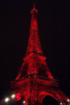 the eiffel tower is lit up in red