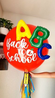 a balloon with the words back to school written on it is being held by a person