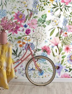 a pink bike is parked in front of a floral wallpaper with flowers on it