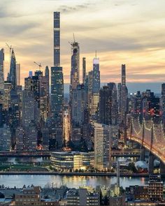 the city skyline is lit up at night, with skyscrapers in the foreground