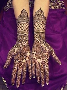 two hands with henna tattoos on them