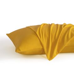 a yellow pillow is folded up to show the folds on it's back end