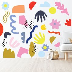 a white couch sitting in front of a wall with colorful art on it's walls