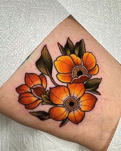 an orange flower tattoo on the leg