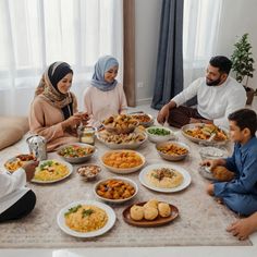 a group of people sitting around a table filled with plates and bowls full of food