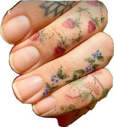 a person's hand with tattoos on it and flowers painted all over the fingers