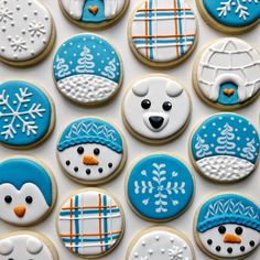 decorated cookies in the shape of snowmen and polar bears are arranged on a white surface