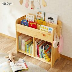 children's bookshelf with wooden shelves and stuffed animals on the floor next to it