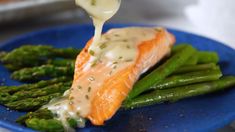 a piece of salmon being drizzled with sauce over asparagus