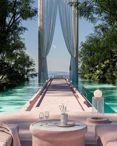 an outdoor area with tables and chairs near the water's edge, surrounded by greenery