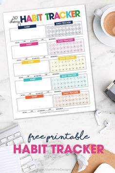 a printable habit tracker on a table with coffee and other items