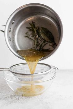 a person pouring mustard into a glass bowl