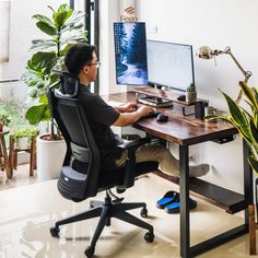 a person sitting at a desk with a monitor and keyboard in front of them, working on a computer