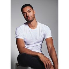 a man in white shirt and black pants sitting down