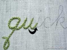 the word joy written in green thread on a piece of white fabric with an arrow