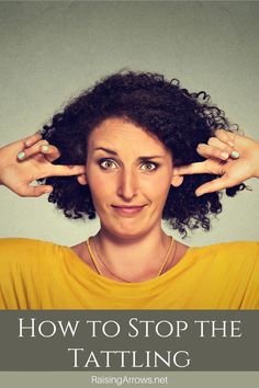 a woman is holding her hands up to her ears and making the shape of two fingers