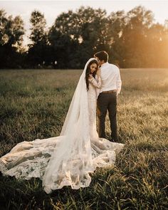 a bride and groom standing in a field at sunset with the sun shining on them