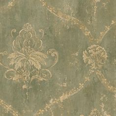 an old wallpaper with gold and green designs on the surface, including leaves and flowers