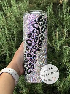 a hand holding a purple and black leopard print tumbler cup with the words, cute tesoros on it