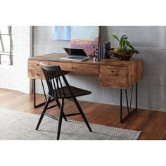 a wooden desk with a laptop on top of it next to a chair and potted plant