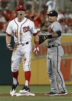 two baseball players standing next to each other on a field