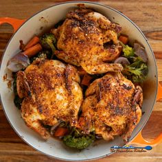 chicken, carrots and broccoli in a pan on a wooden table top