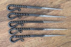 five pairs of scissors sitting on top of a wooden table