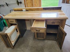 a wooden desk with drawers in a storage area next to a garage door and window