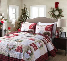 a christmas themed bed with red and white quilted bedspread, pillows and decorations