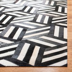 a black and white area rug on a wooden floor