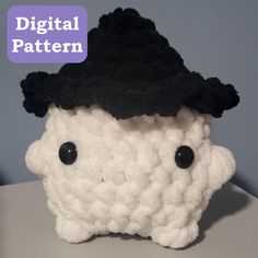 there is a crocheted sheep with a black hat on it's head