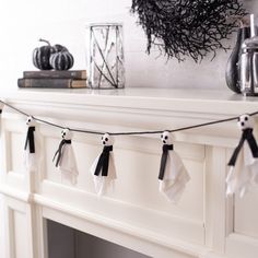 halloween decorations are hanging on the mantle in front of a fireplace with books and candles