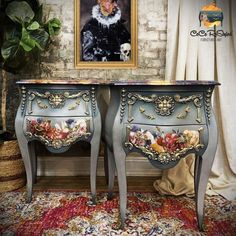 an ornately decorated table with two drawers and a painting on the wall behind it