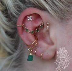 a close up of a person's ear with some piercings on top of it