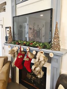 stockings hanging from the mantel in front of a fireplace with christmas decorations on it