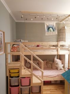 the bunk bed is made out of wood and has lots of storage containers underneath it