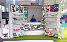 a man standing in front of a display case with many books on it's sides