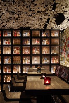 a long table with candles on it in front of a book shelf filled with books