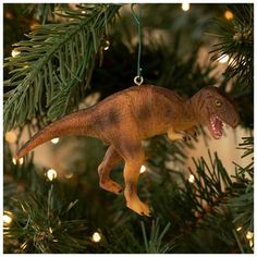 a dinosaur ornament hanging from a christmas tree