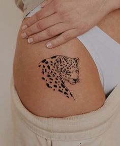 a woman's stomach with a tattoo of a cheetah on the side